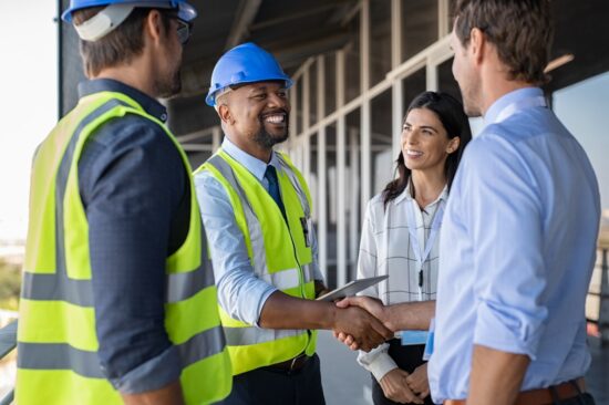 engineers and business man shake hands