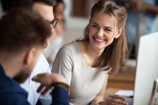 smiley young woman talking with colleague