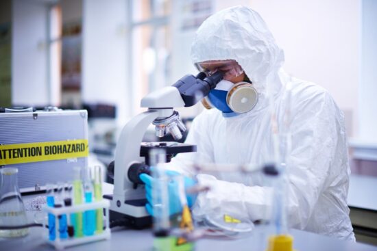 lab worker looking through microscope