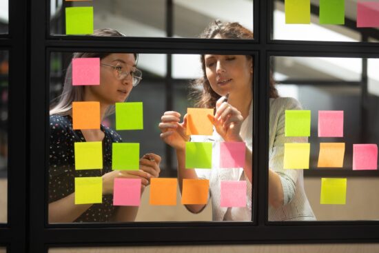 colleagues brainstorming ideas on post-it notes