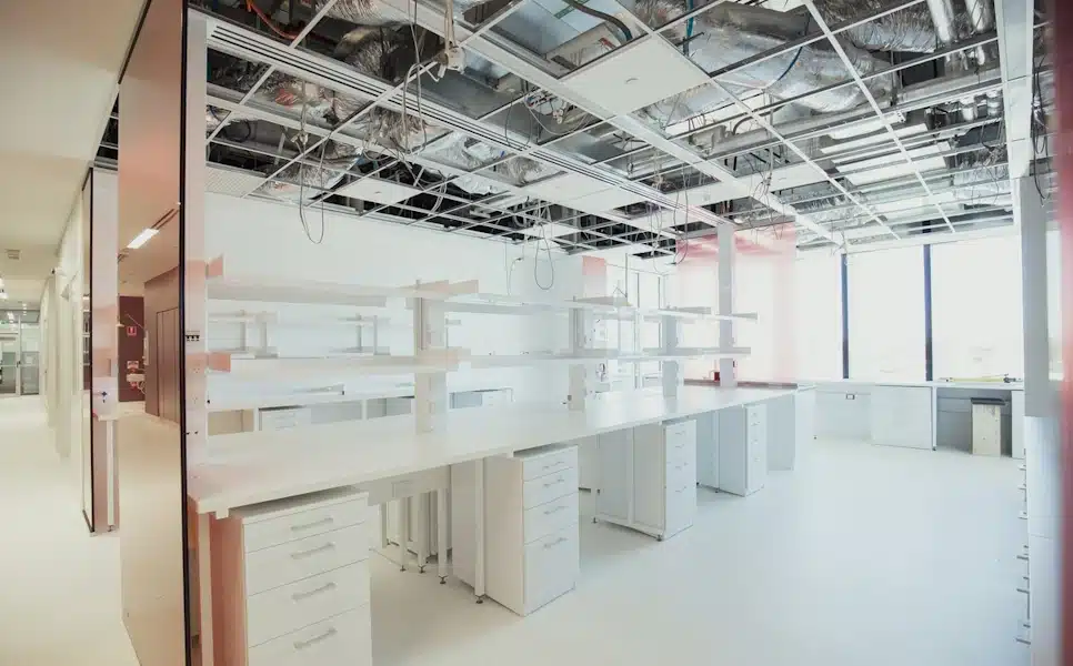 A shot of an empty modern science research laboratory, desk spaces for experiments and research can be seen around the room.