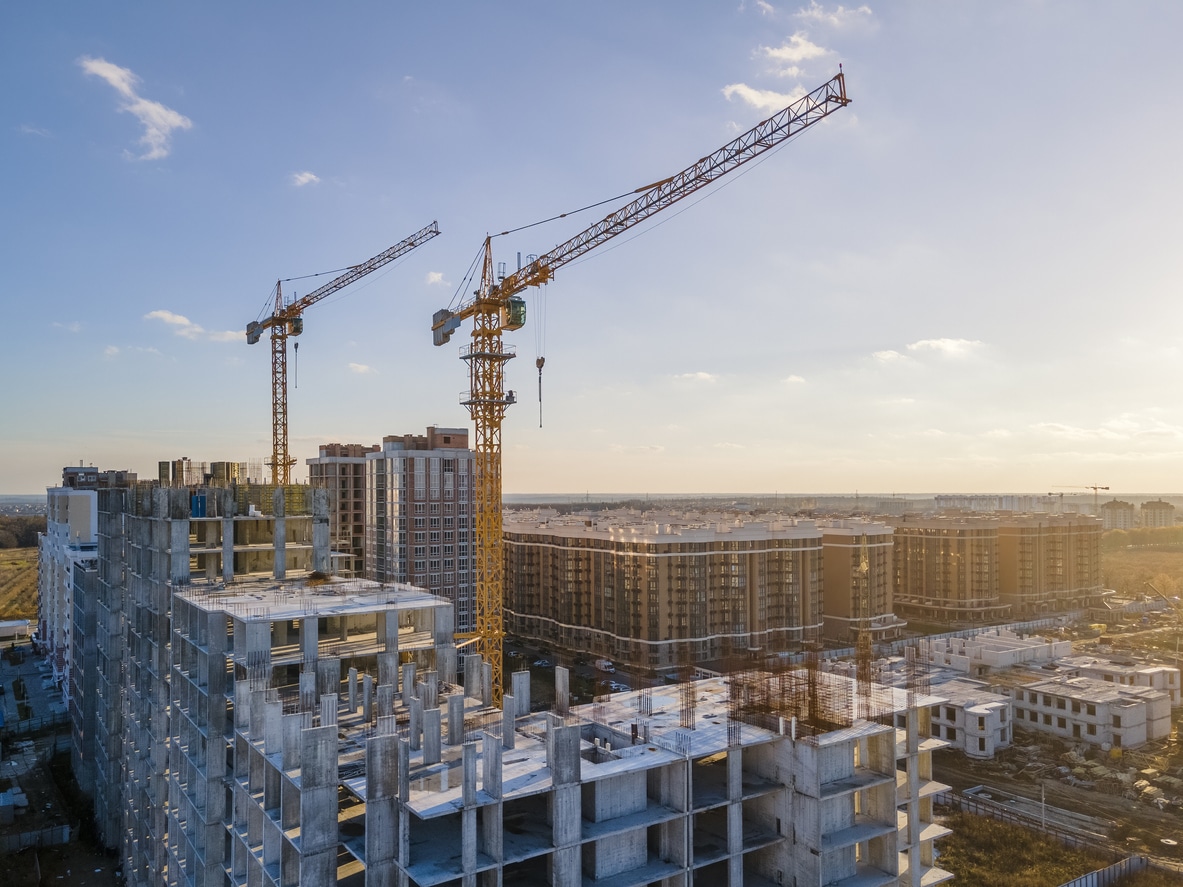 Cranes on the construction site surrounded by new real estates.