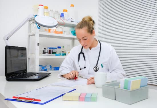 Experienced medical practitioner checks patients records