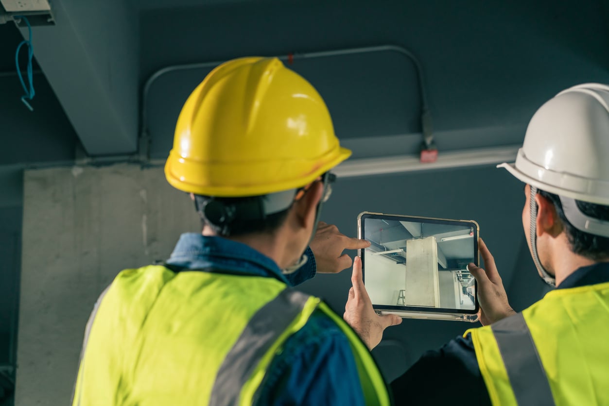 Selective focus Tablet on hand Civil Engineer and Contractor working in construction site. Team Architect working use BIM technology and digital construction application on digital tablet.