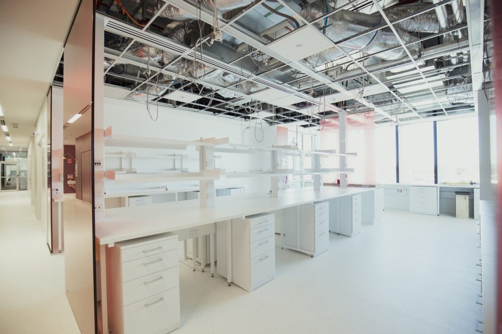 A shot of an empty modern science research laboratory, desk spaces for experiments and research can be seen around the room.