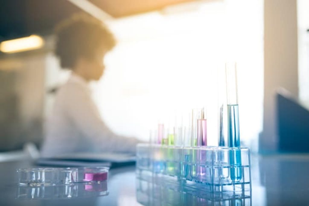 A young African American woman doing research in the laboratory and making notes