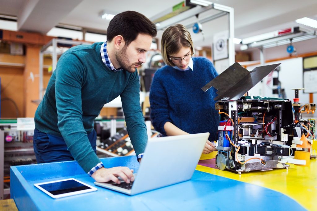 Young students of robotics working on project together